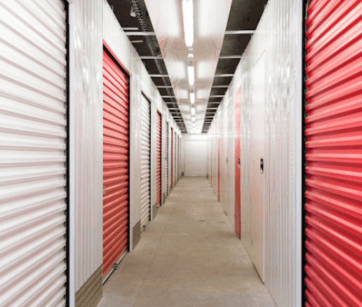 Couloir intérieur avec rangées de portes de boxes rouges et blanches du centre HOMEBOX Madrid Ramon y Cajal