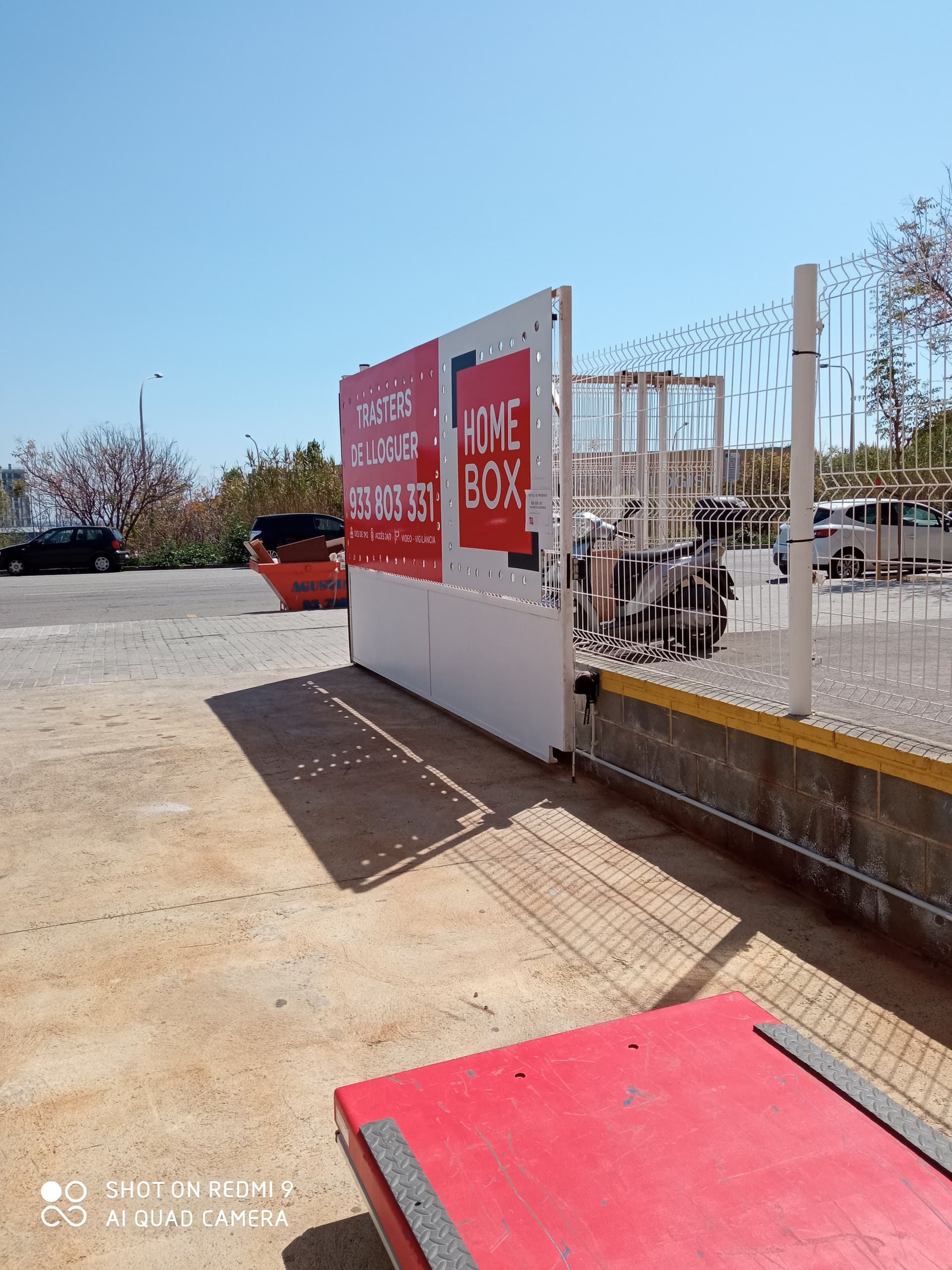 Outdoor signage gate with HOMEBOX panel and platform trolley at HOMEBOX Mataró, Carrer Josep Calvet, 28 0 Mataró Barcelona, Mataró